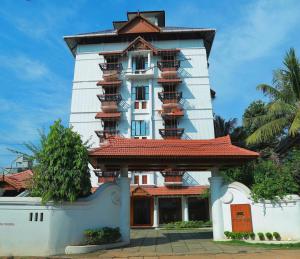 a tall white building with balconies on it at Padipura Residency in Alleppey