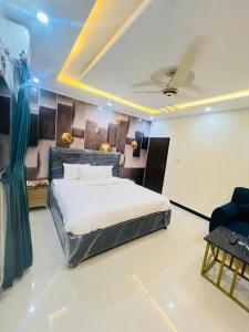 a bedroom with a large bed and a blue chair at Rose Family Lodges in Islamabad