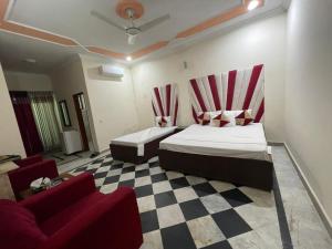 a bedroom with two beds and a checkered floor at Rose Family Lodges in Islamabad +5 photos