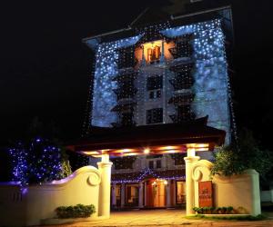 a hotel with christmas lights on it at night at Padipura Residency in Alleppey +2 photos