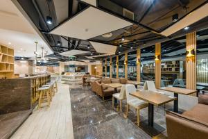 a restaurant with tables and chairs and a bar at 亚轻x酒店上海同济医院新村路地铁站店 in Shanghai