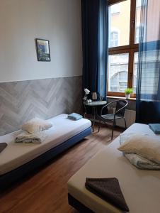 a bedroom with two beds and a table and a window at Rynek 7 in Katowice