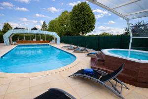 a swimming pool with chairs and a hot tub at Logis Hotel Restaurant L'Escapade in Le Pêchereau