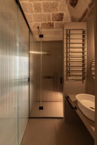 a bathroom with a glass shower and a sink at Palazzo Cerere Boutique Hotel in Polignano a Mare