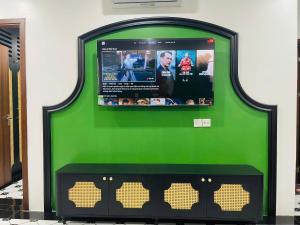 a green wall with a flat screen tv on it at Green Park Lang Son Apartment in Lạng Sơn