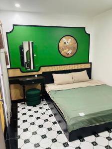 a room with two beds and a clock on the wall at Green Park Lang Son Apartment in Lạng Sơn