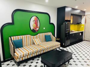 a living room with a couch and a green wall at Green Park Lang Son Apartment in Lạng Sơn