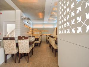 a dining room with chairs and a wall with butterflies at Hotel Grand Eagle Group in Jaipur