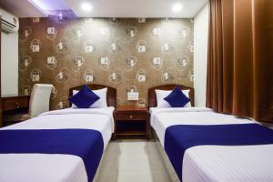 a hotel room with two beds and a wall with plates at Hotel Grand Eagle Group in Jaipur