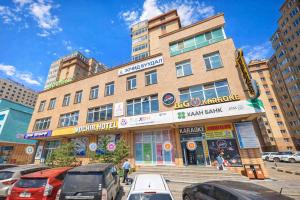 a building with cars parked in front of it at Ochir Hotel in Ulaanbaatar