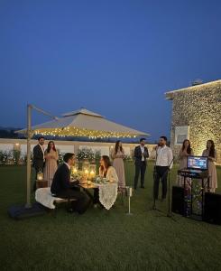 a group of people sitting around a table with candles at Privé Residence in Rāmnagar +36 photos