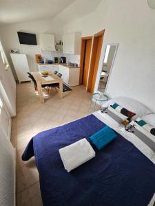 a bedroom with a blue bed and a kitchen at Perla Mare in Sumartin