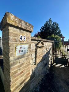 a brick wall with a sign on it at Villa Giulia apartment Assisi in Castelnuovo