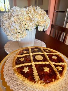 a pie sitting on a table with a vase of flowers at Villa Giulia apartment Assisi in Castelnuovo