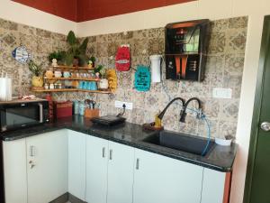 a kitchen with a sink and a microwave at Amaiti pool villa in Bangalore