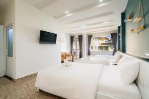 a living room with a white couch and a tv at Gia Khanh Hotel in Da Lat +15 photos