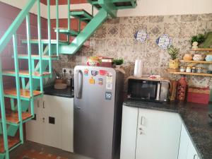 a kitchen with a refrigerator and a staircase at Amaiti pool villa in Bangalore