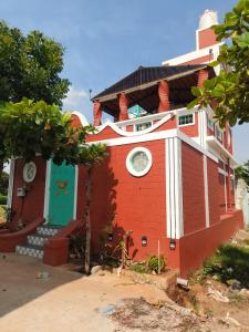 a red and white house with a clock on it at Amaiti pool villa in Bangalore +23 photos