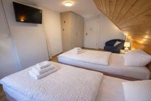 a room with two beds with white towels on them at Ferienzimmer Präkel in Kloster