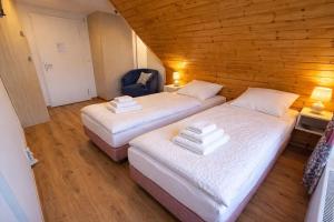 two beds in a room with wooden walls at Ferienzimmer Präkel in Kloster