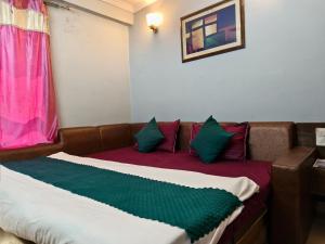 a room with a couch with pillows on it at Hotel Shaurya By Sharma 0nline Solution Haridwar in Haridwār +46 photos