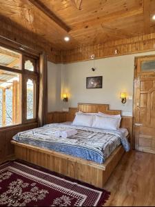 a bedroom with a large bed in a wooden room at Cosy Crest in Banjār +8 photos