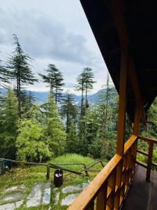 a view of a forest from the porch of a cabin at Cosy Crest in Banjār