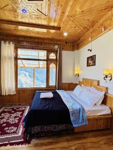 a bed in a room with a wooden ceiling at Cosy Crest in Banjār