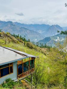 a house on a hill with mountains in the background at Cosy Crest in Banjār