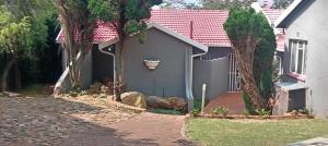 a gray house with a flower pot on the side of it at Suburban tranquility in Johannesburg