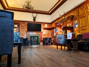 a living room with a fireplace and a television at The Caledonian Claymore Hotel in Arrochar