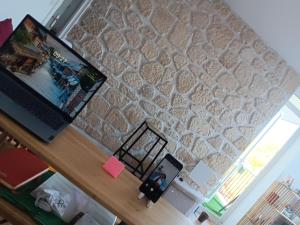 a room with a stone wall and a laptop on a desk at Olembe Garden in Avon