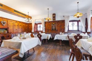 a restaurant with white tables and chairs and windows at Hotel Walchseer Hof in Walchsee +16 photos