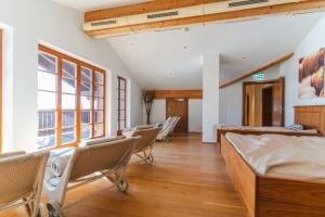 a room with chairs and a bed and windows at Hotel Walchseer Hof in Walchsee
