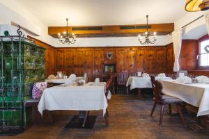 a dining room with two tables with white tablecloths at Hotel Walchseer Hof in Walchsee