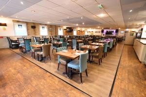a dining room with wooden tables and chairs at The Caledonian Claymore Hotel in Arrochar +13 photos