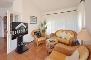 a living room with couches and chairs and a sign at Quatre vents Ref 163 in Begur
