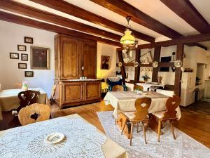 a living room with two tables and chairs and a chandelier at L'Héritage 1779 in Duntzenheim