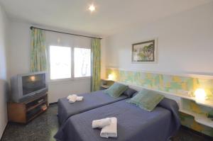 a hotel room with two beds and a television at Quatre vents Ref 163 in Begur +11 photos