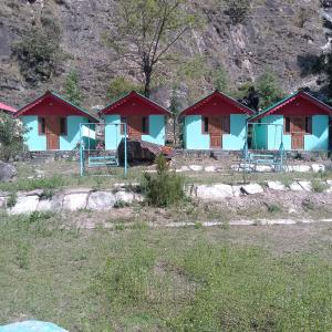 a row of cottages with red roofs in a field at Shoolin camping in Jari