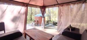 a screened in porch with a table and a gazebo at Odpocznij w Lesie in Biały Dwór +18 photos