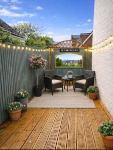 a patio with chairs and a table and a fence at The Cask Room in Scarborough