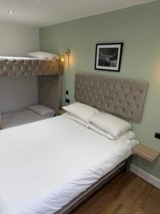 a bedroom with a bed with white sheets and pillows at west park hotel PVT ltd in Clydebank
