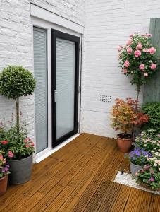 a patio with potted plants and a door with flowers at The Cask Room in Scarborough