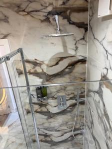 a bathroom with a shower with a stone wall at west park hotel PVT ltd in Clydebank