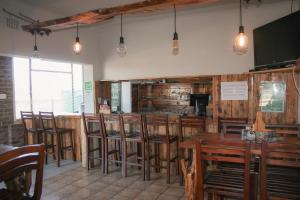 a restaurant with a bar with wooden tables and chairs at Heydays B&B in Noupoort