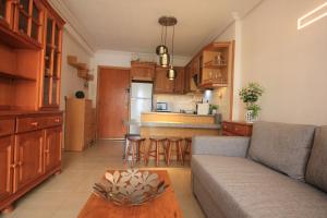 a living room with a couch and a kitchen at Apartment La Turquesa in La Pineda