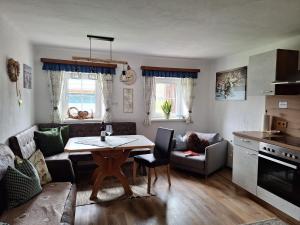 a living room with a table and a couch at Loitzbauer Ferienwohnungen in Sankt Gilgen