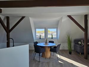 a living room with a table and chairs at Ferienwohnungen Stadtblick, 15208 - Nur für Urlaubsgäste! in Leer