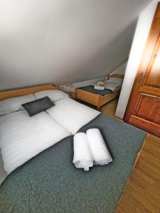 a bedroom with a large white bed with two towels at Apartma Brin Rogla in Zreče +24 photos
